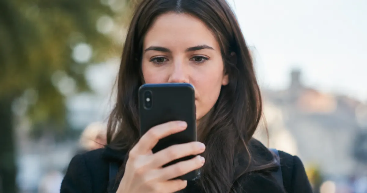 Personne tenant telephone mobile vertical devant visage