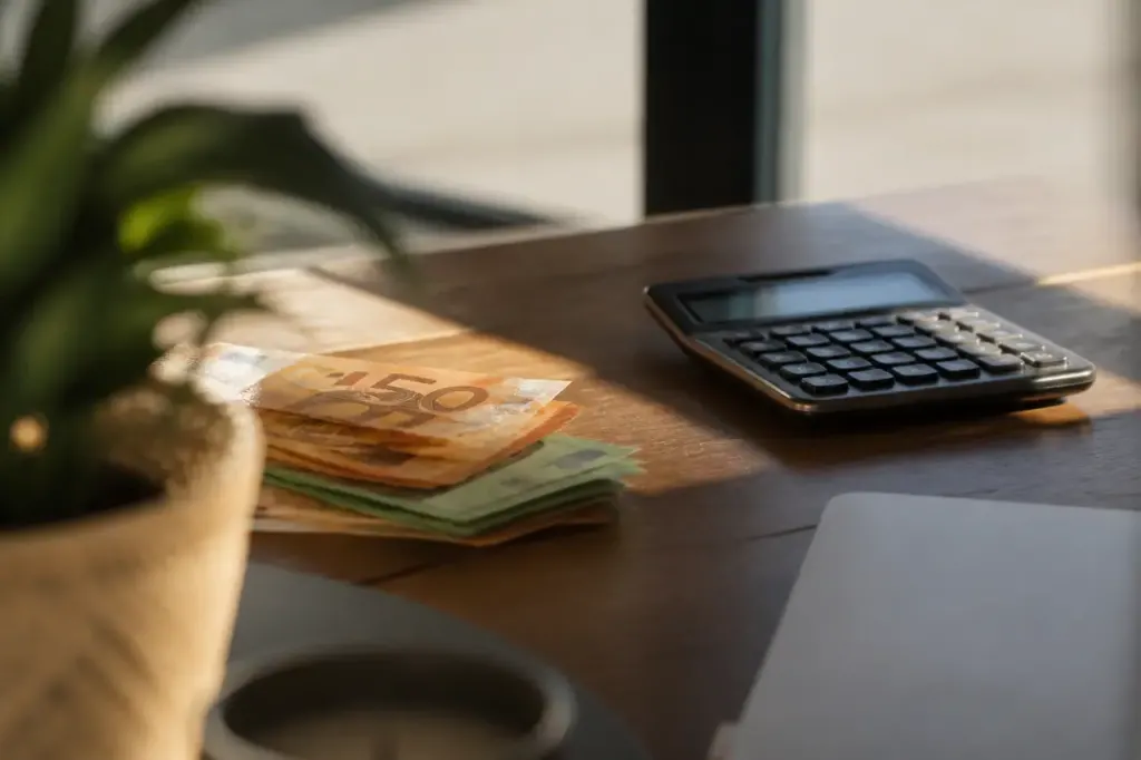 Billets et calculatrice poses sur un bureau