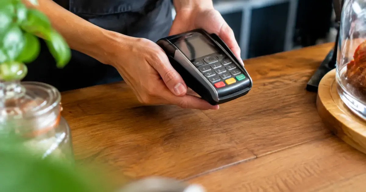 Caissier tenant un terminal portable sur le comptoir