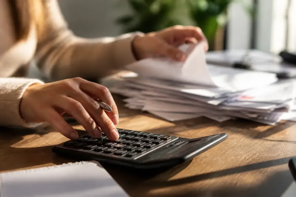 Calculatrice, stylo et factures posées sur un bureau
