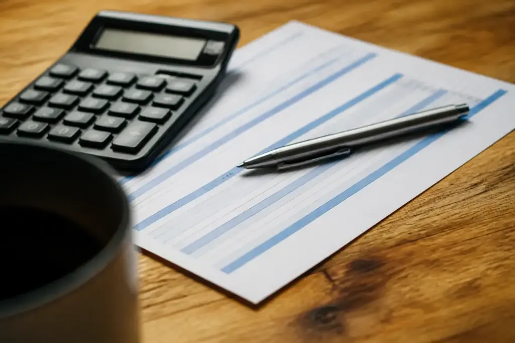 Calculatrice et stylo poses sur un releve bancaire