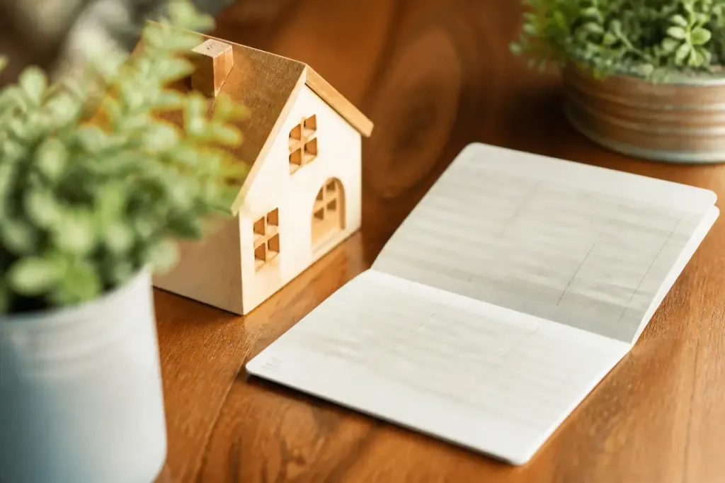 Carnet epargne ouvert sur table avec petite maison