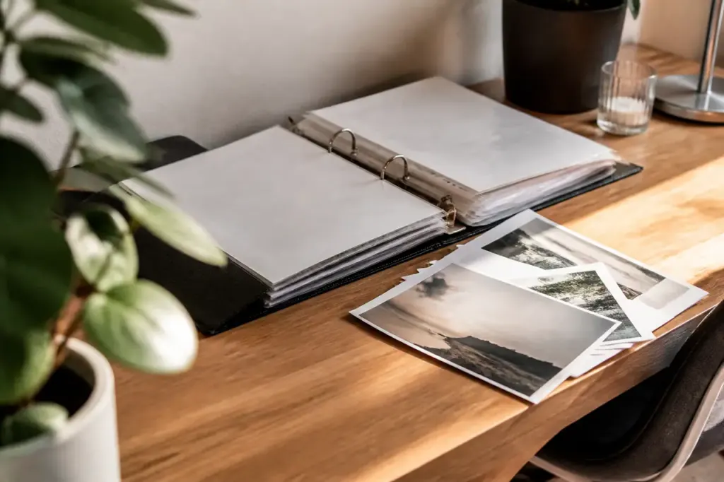 Classeur ouvert, factures et photos imprimees sur un bureau