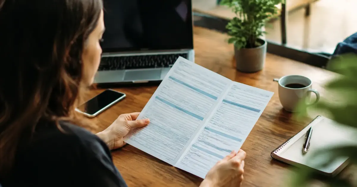 Employe assis au bureau tenant un formulaire ouvert