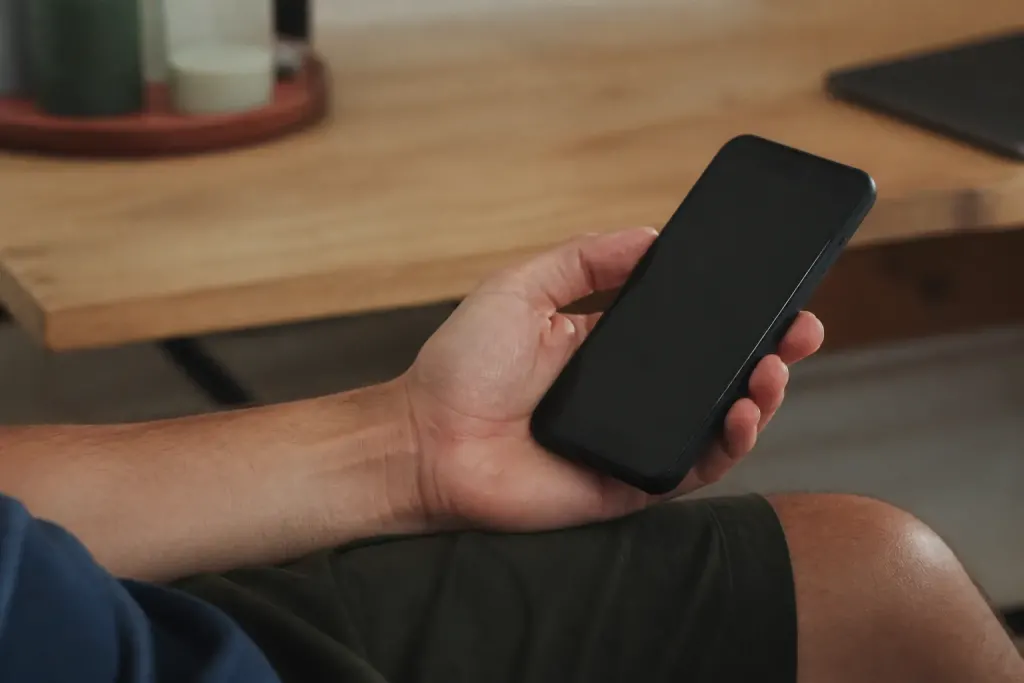 Main tenant un smartphone affichant un appel inconnu