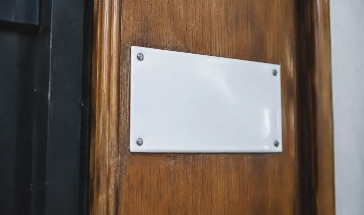 Plaque metallique emaillee blanche fixee sur porte bois