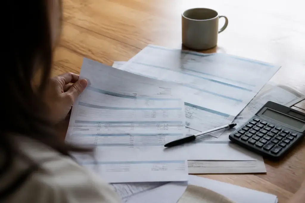 Releves bancaires etales sur table avec stylo et calculatrice