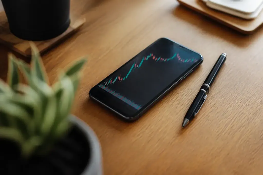 Smartphone avec graphique et stylo pose sur table