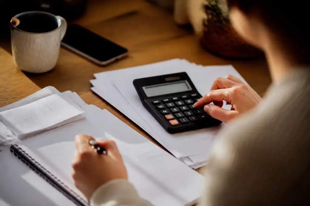 Table avec calculatrice, factures et carnet de notes