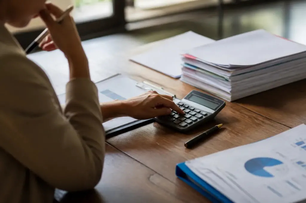 Table de reunion avec dossiers budgetaires, calculatrice et stylo