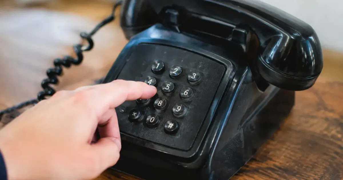 Doigt appuyant sur touches numeriques telephone retro noir