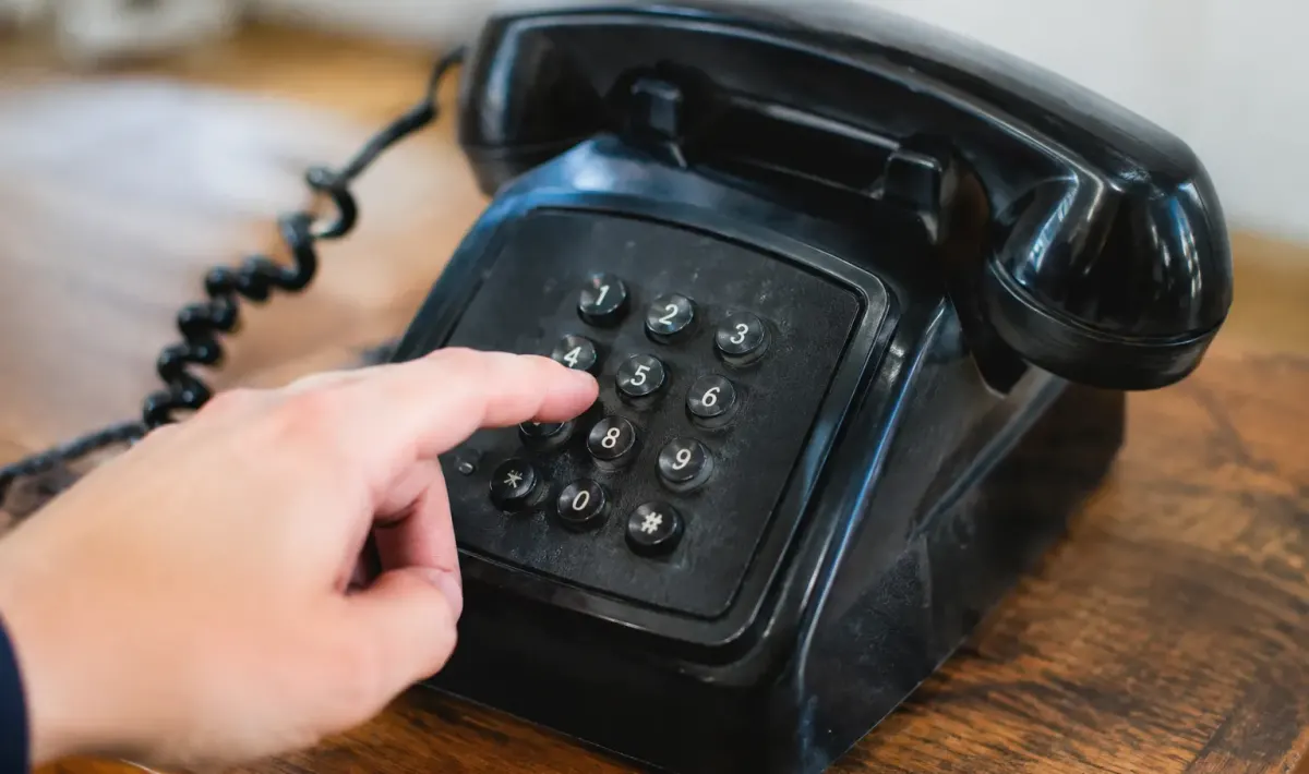 Doigt appuyant sur touches numeriques telephone retro noir