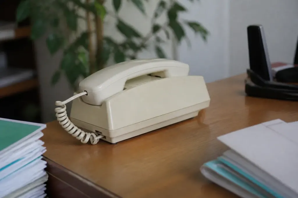 Vieux telephone fixe beige pose sur un bureau